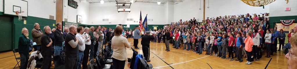 veterans and students stand for a flag ceremony