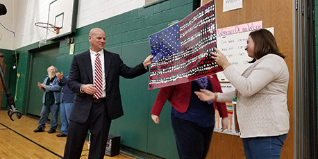 principal michael teator receives a painted american flag