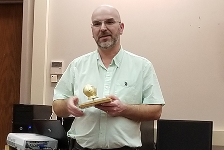 scott gray poses with his golden knight award