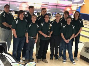 the boys varsity bowling team poses with their trophy