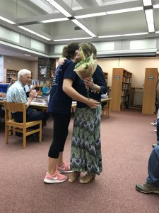 a retiree hugs a student at the may 23 BOE meeting