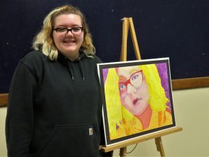 Ellise Hunt poses with her artwork.