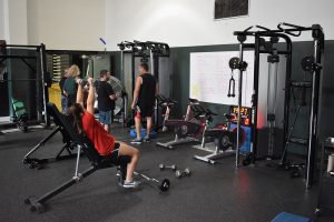 students use the equipment in the weight room