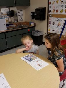 pre-k and 3rd grade students read together