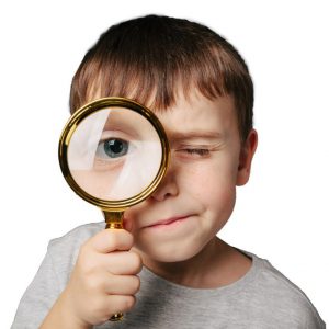 student with magnifying lens