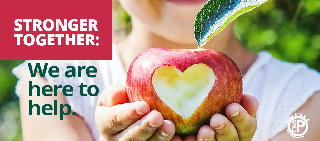 Child holds apple with a bite mark in the shape of a heart. It says, Stronger Together: We are here to help