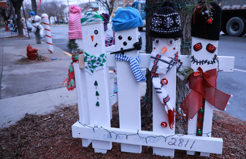 Main Street snowmen art made out of a picket fence and candy canes covering meters