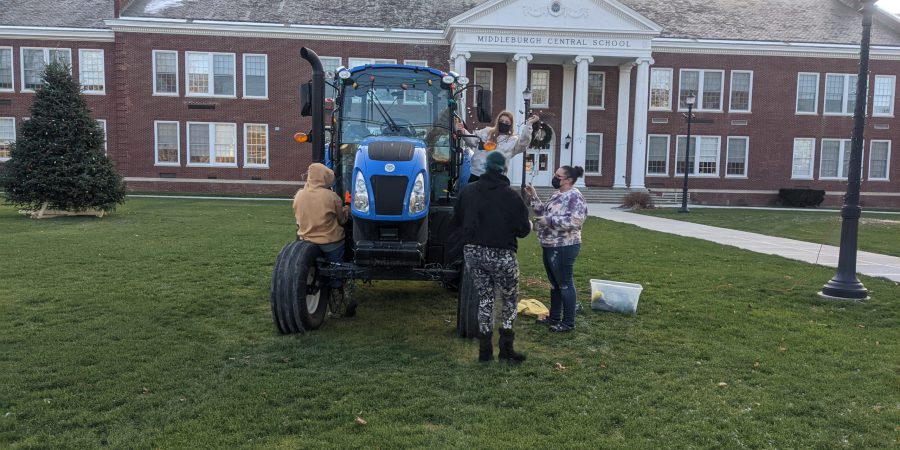 FFA officers decorating a tractor with lights for the holidays