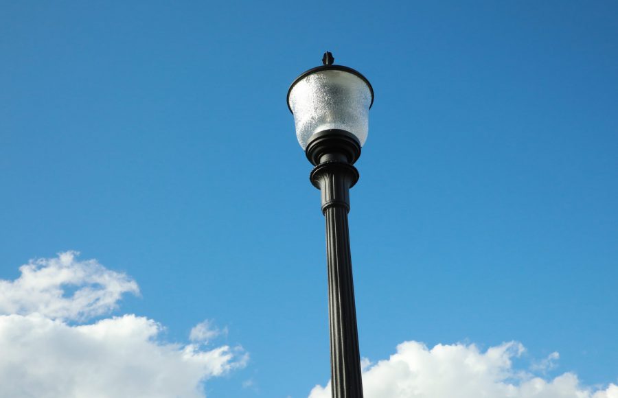 A lightpost and bright blue sky with fluffy clouds