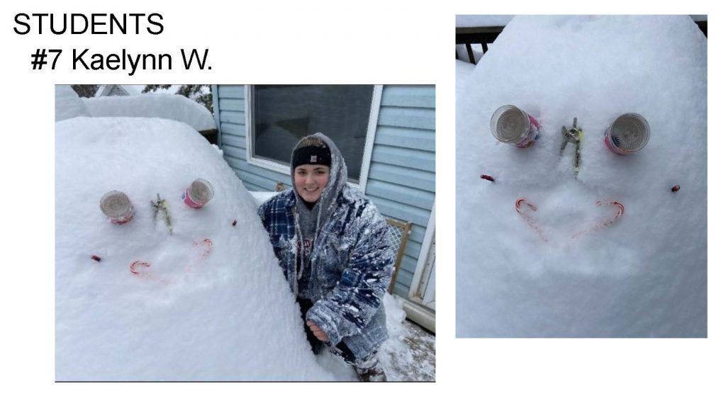 snowman with cannned food for eyes, candy canes for a mouth and a student covered in snow sitting next to it.