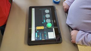young student works on tablet to create code