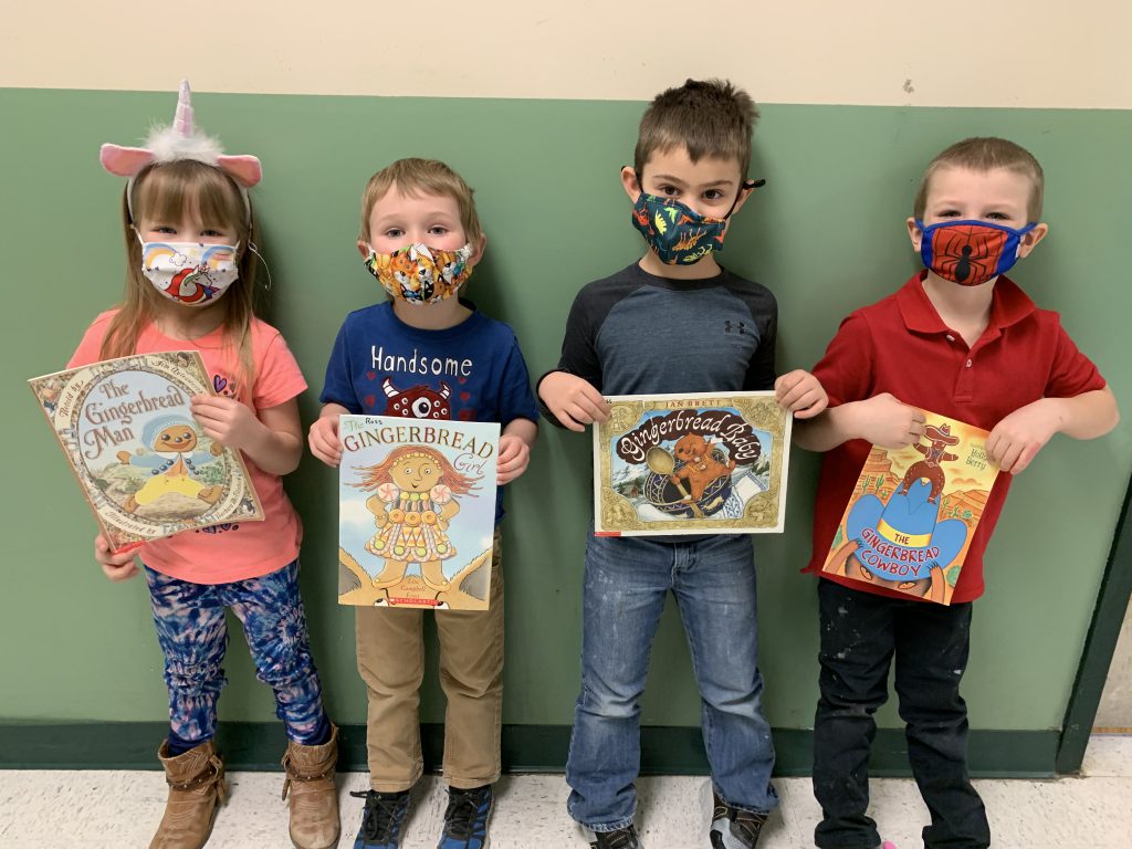 four kindergarted students each holding a book about gingermen