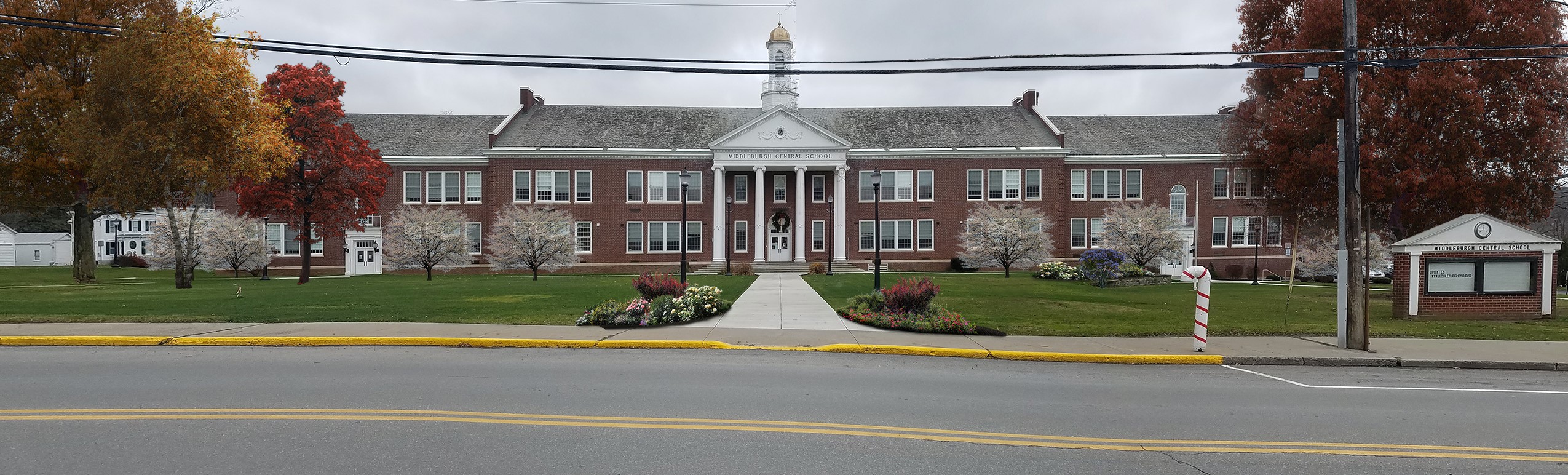 front of brick high school with trees lining the building