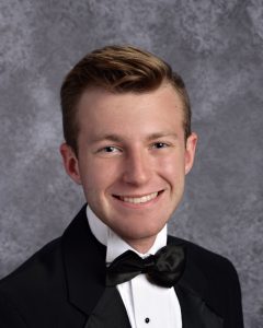 student senior picture in a tux with black bowtoe and nice red-brown hair and nice smile