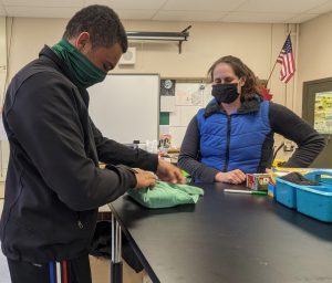 Student wraps a surgical pack with a vet watching.