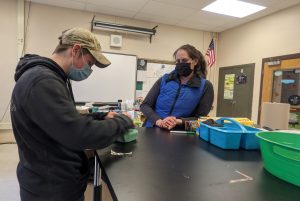 Vet watches student wrap a surgical pack.