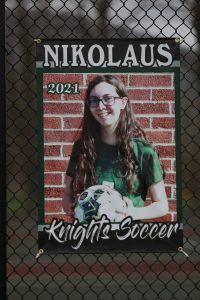 soccer player with long brown hair and glasses