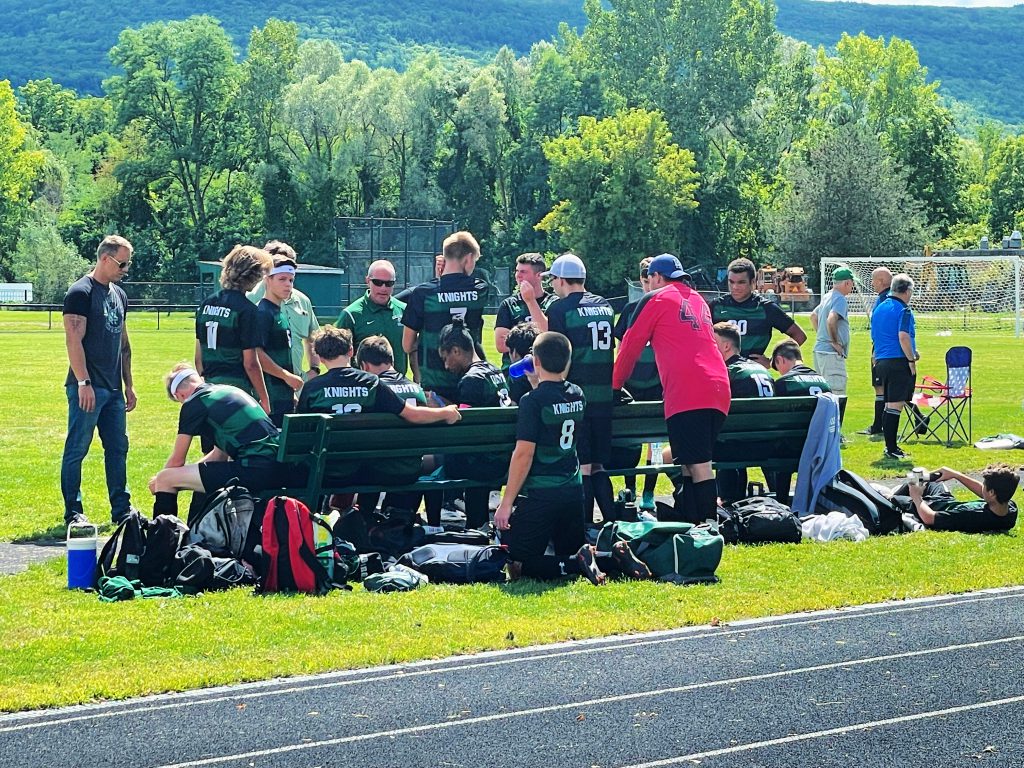 soccer team listening to coach on the sidelines