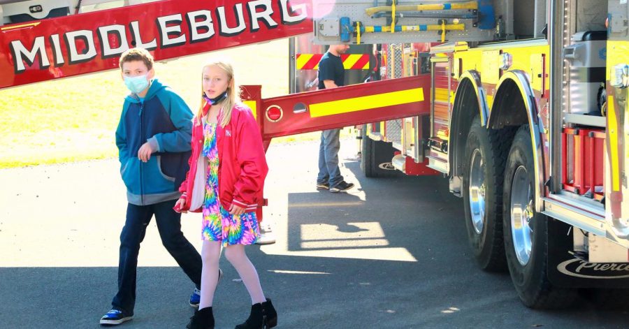 two students walking in front of a fire truck with the words Middleburgh