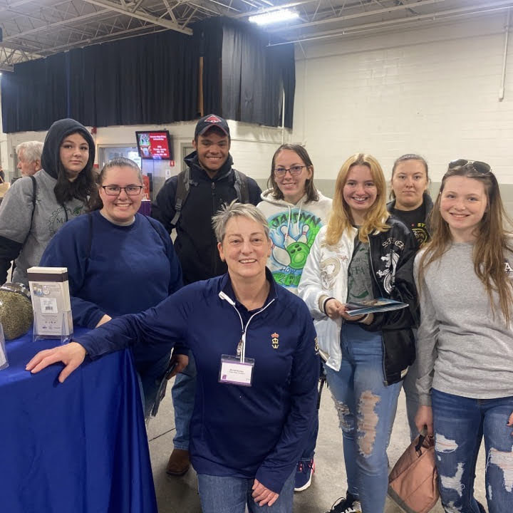 seven students smiling for a picture surrounding an equine specialist 