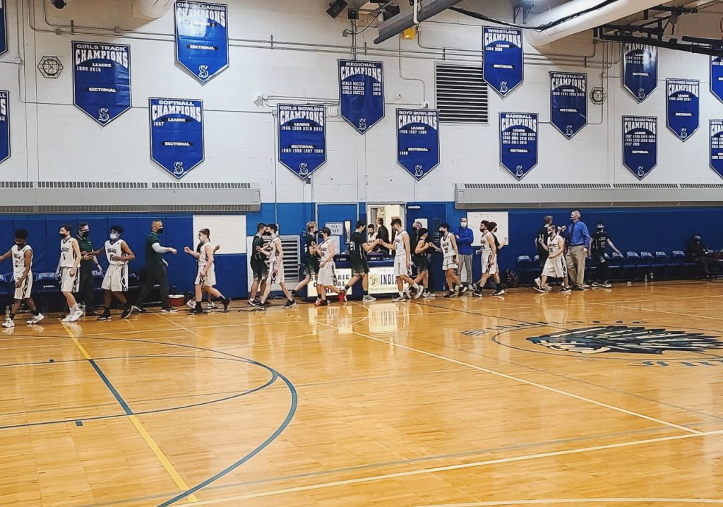 two basketball teams bumping fists after game