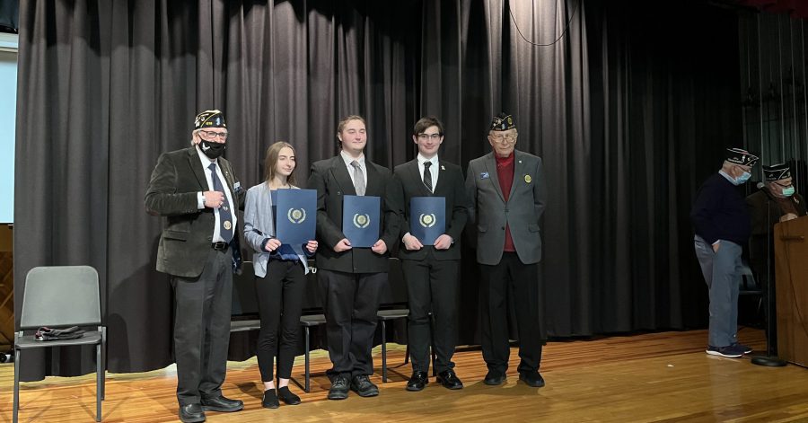three students holding awards with two American Legion members on each side of them