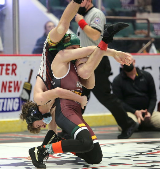 student wrestler holds other wrestler over his head