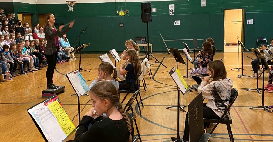 band teacher conducts students in gym concert
