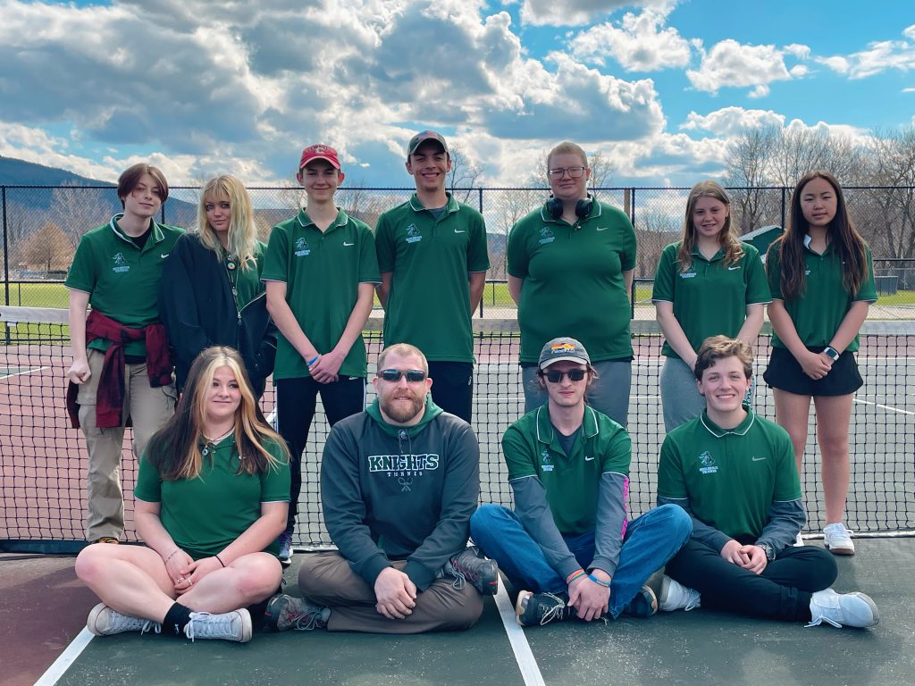 tennis team standing and sitting on the court for a group picture