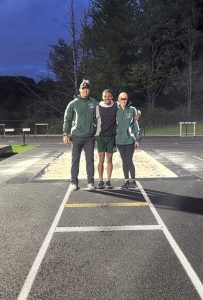 two coaches stand between a track star