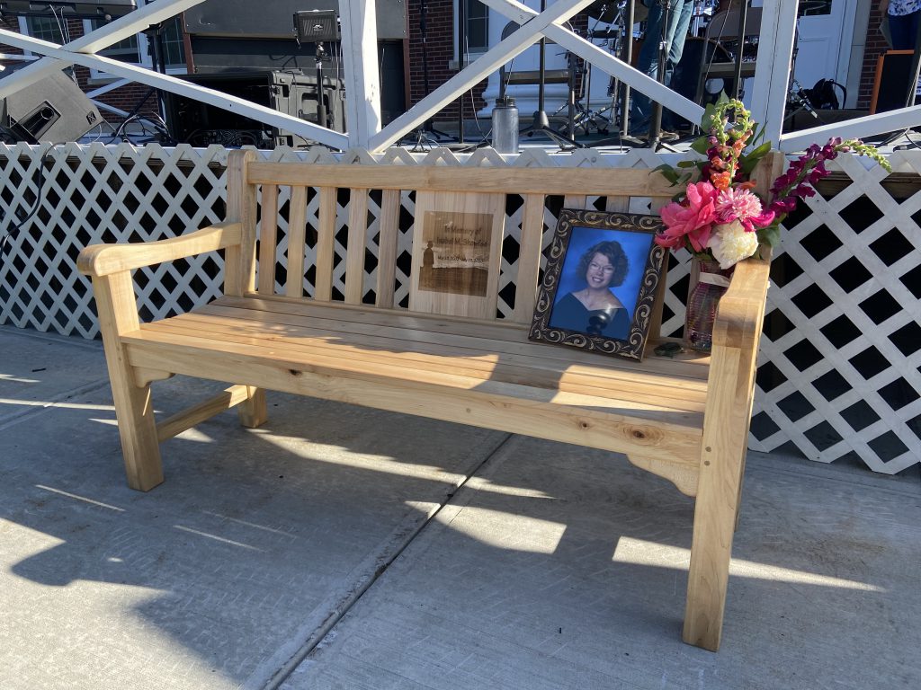 memorial bench with photo in a frame sitting on the bench