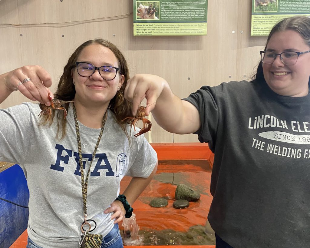 Students hold up crawdads