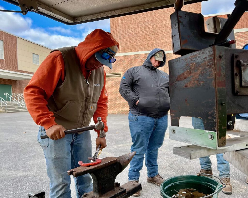 Students weld a horseshoe