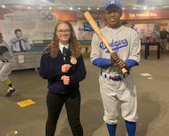 A student in an FFA jacket poses next to a statue of Jackie Robinson