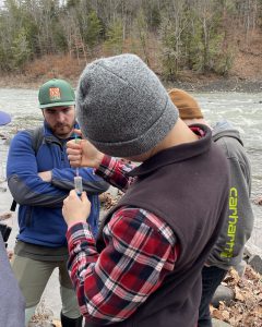 Students stand near a stream