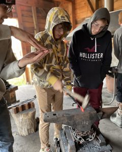 Students look at a blacksmith's anvil