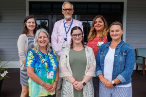 Six members of the School-based Health Care team stand together looking toward the camera.