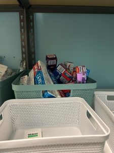 Bins, some containing toothpaste, others empty are pictured on the shelves of the Community Closet.