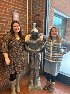 New social work team stand next to a knight statue at Middleburgh Elementary. They are smiling and looking toward the camera.