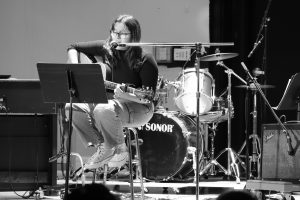 A teen girl sings and plays guitar