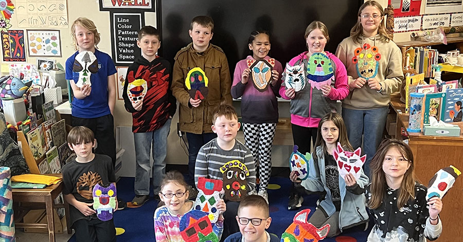 4th graders with art they created for lesson on Native American Iroquois False Face Masks.