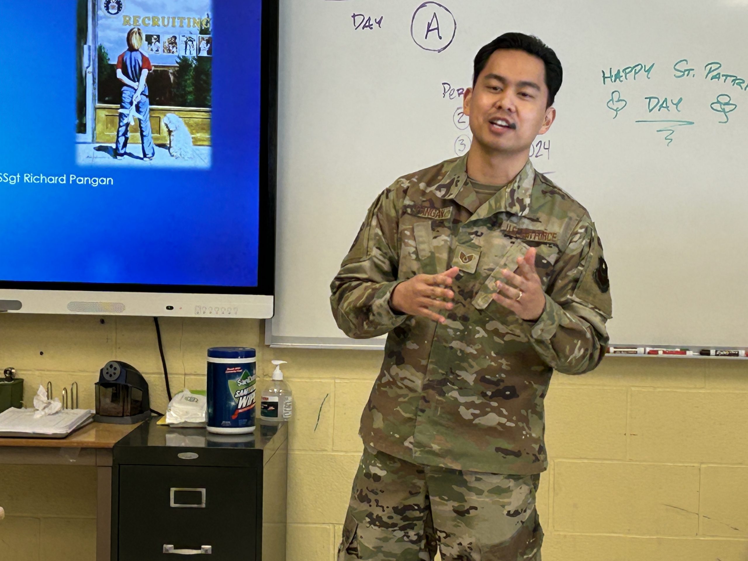 Staff Sergeant Rich Pangan; stands in front of classroom.