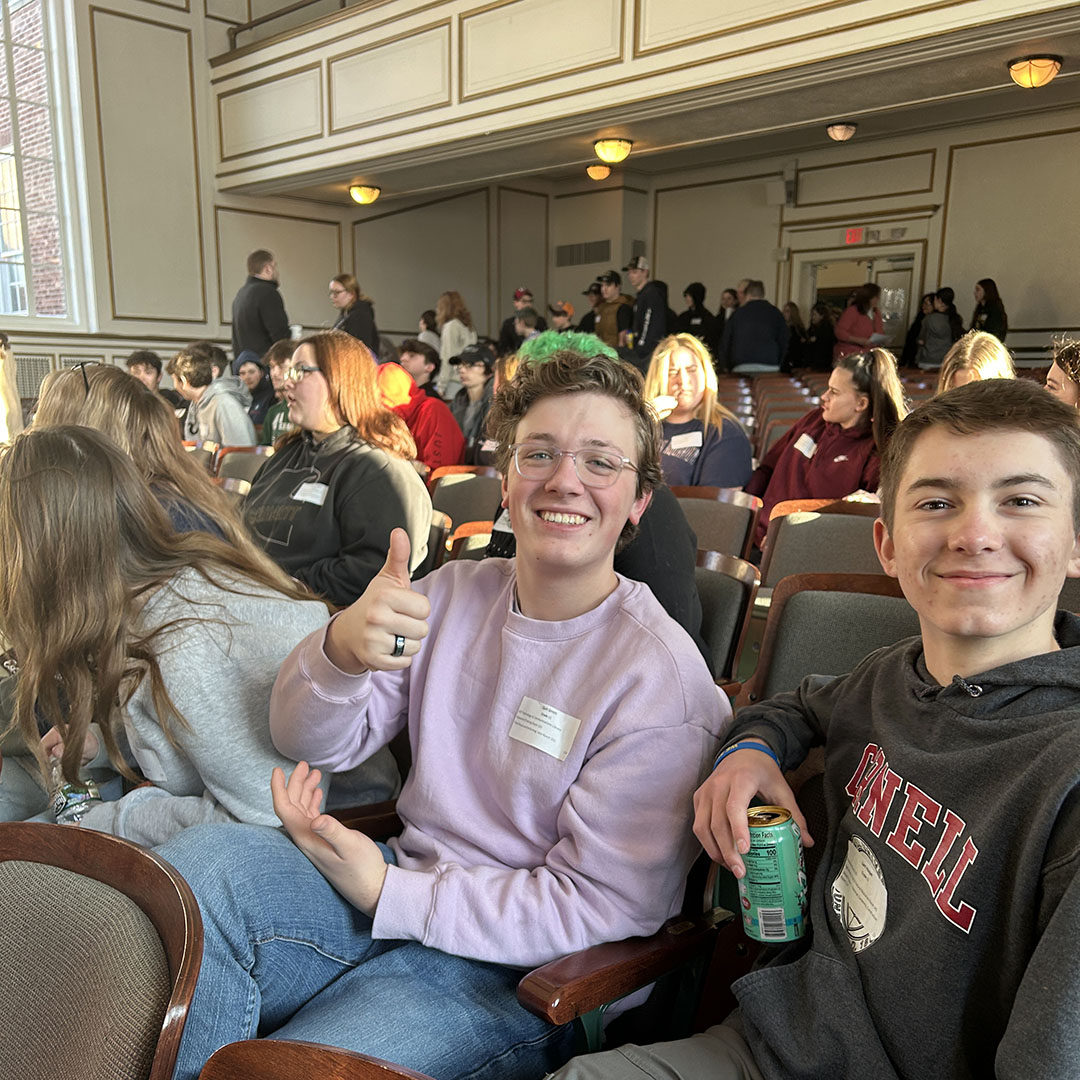 Students in auditorium give a thumbs up.