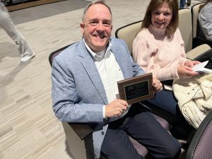 former Middleburgh Band teacher George Meyer holds plaque of service from the Schoharie County Music Educators Association 