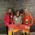 Denise Colistra, Sarah Schafroth and Olivia Skowfoe stand with FBLA Travel Agency poster
