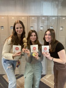 Three students stand with Albert Einstein statue.