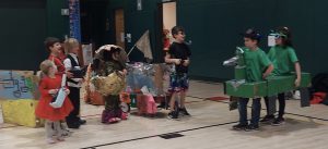 Children wearing costumes and holding a homemade dragon.