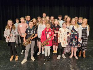 Students stand with instruments.