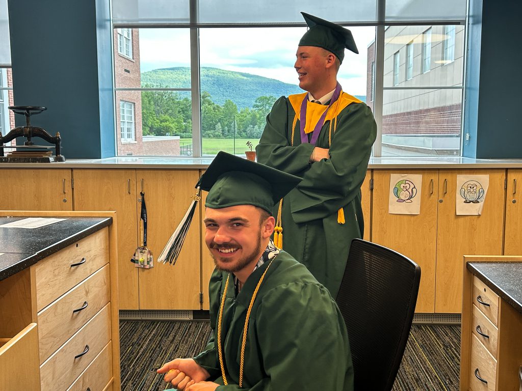 Two students smiling in cap and gown