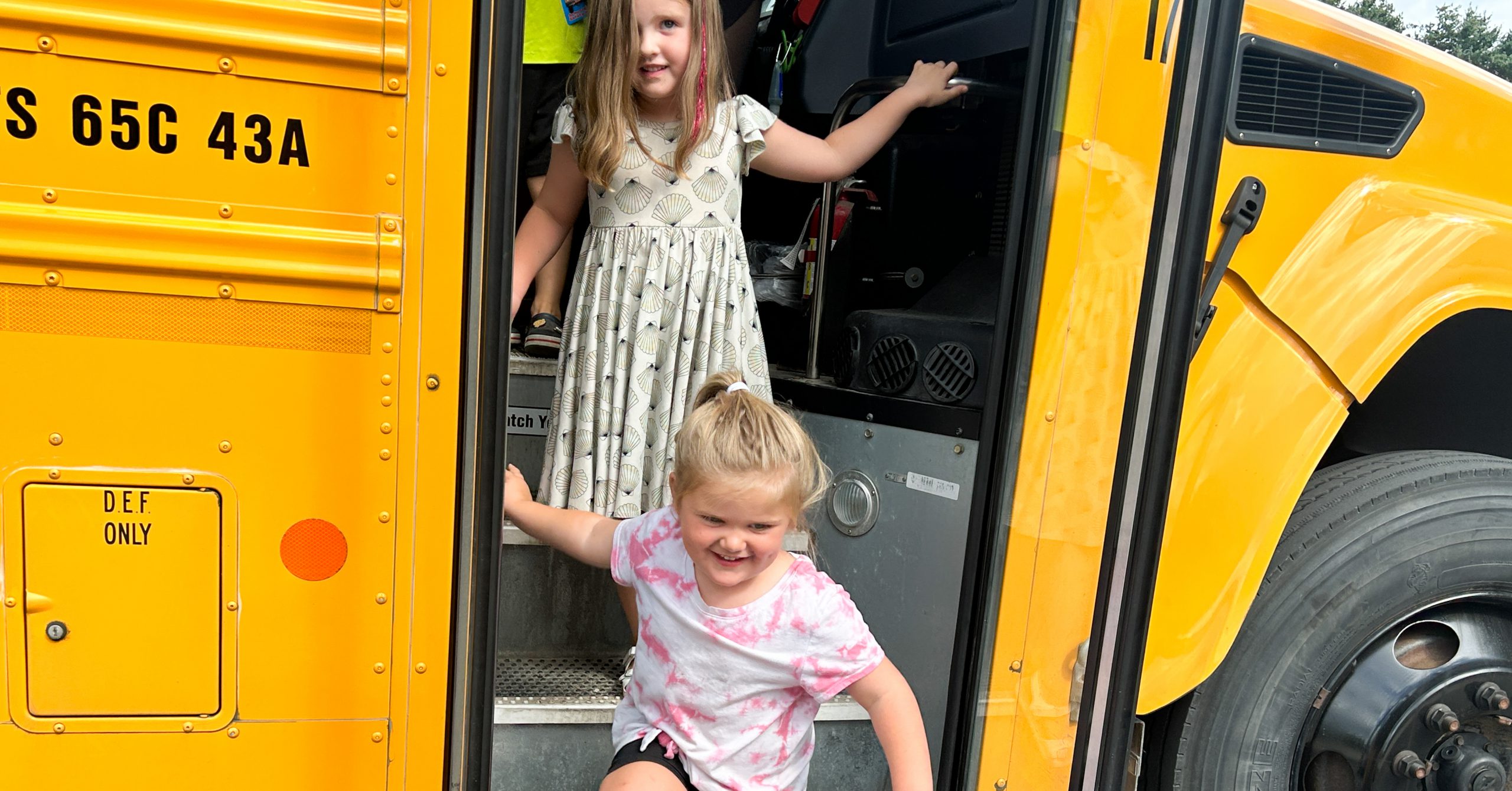 Two girls getting off the bus 